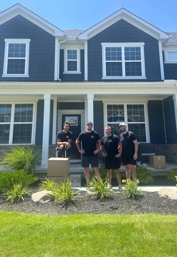 M&S Moving Services team standing in front of a house, showcasing their partnership with LuceDev LLC for website development.